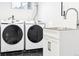 A close up of the laundry area featuring new machines, a sink, and modern black hexagon tile flooring at 1591 Holly St, Denver, CO 80220