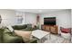 Comfortable living room with a green sectional sofa, marble coffee table, and a flat screen television at 1591 Holly St, Denver, CO 80220