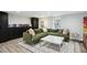 Well-lit living room features a green sectional sofa, marble coffee table, and adjacent shelving unit at 1591 Holly St, Denver, CO 80220