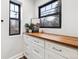 Pantry area with custom white cabinets, butcher block countertop, black framed windows, and stylish decor at 1591 Holly St, Denver, CO 80220