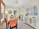 Bright dining area with carpet flooring, a glass-top table and orange chairs and a decorative white cabinet at 1256 S Pennsylvania St, Denver, CO 80210