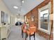 Open-concept living area with brick accent wall, skylight, carpet, and a comfortable seating area with orange dining set at 1256 S Pennsylvania St, Denver, CO 80210