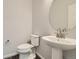 Clean bathroom with pedestal sink and round mirror at 13840 Deertrack Ln, Parker, CO 80134