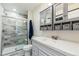 Renovated bathroom with a glass-enclosed shower, storage shelves, and stylish vanity at 5385 W 51St Ave, Denver, CO 80212