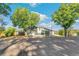 Charming home featuring a driveway, a well-kept lawn, and mature trees surrounding the property at 5385 W 51St Ave, Denver, CO 80212