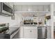 Open kitchen with stainless steel appliances, granite counters, and sightlines to the living room at 5385 W 51St Ave, Denver, CO 80212