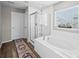 Clean bathroom with soaking tub, glass-enclosed shower and white tile at 9716 Uravan St, Commerce City, CO 80022