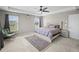 Well-lit bedroom boasts carpeted floors, a ceiling fan and two large windows at 9716 Uravan St, Commerce City, CO 80022