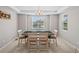 Dining room featuring tray ceiling, natural light, a modern chandelier and neutral color palette at 9716 Uravan St, Commerce City, CO 80022