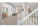 Inviting foyer with neutral walls, carpeted floor, and a staircase with white railings at 9716 Uravan St, Commerce City, CO 80022