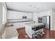 The updated kitchen features white cabinets, stainless steel appliances and a granite countertop island at 9716 Uravan St, Commerce City, CO 80022
