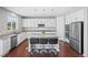 Updated kitchen features white cabinets, stainless steel appliances and a granite countertop island at 9716 Uravan St, Commerce City, CO 80022