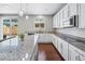 Bright kitchen features white cabinets, stainless steel appliances and a granite countertop island at 9716 Uravan St, Commerce City, CO 80022