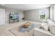 Bright living room features a large window, cozy sofa, and decorative rug at 9716 Uravan St, Commerce City, CO 80022