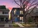 Contemporary two-story home featuring dark siding, blue doors, balconies, and mature landscaping with a tree at 3538 Pecos St, Denver, CO 80211