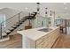 Large kitchen island includes gas cooktop, sink, and drawers with adjacent staircase at 3538 Pecos St, Denver, CO 80211