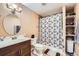 Well-lit bathroom featuring a vanity, toilet, and shower with a stylish shower curtain at 19431 E Wyoming Ave, Aurora, CO 80017