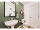 Stylish half-bathroom featuring green walls, modern fixtures, and a charming design at 19431 E Wyoming Ave, Aurora, CO 80017