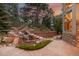 Backyard with a charming rock waterfall feature amid lush landscaping and mature trees at 20166 E Shady Ridge Rd, Parker, CO 80134