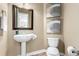 Bathroom features a white pedestal sink, sleek toilet, and modern art pieces, creating a clean and functional space at 20166 E Shady Ridge Rd, Parker, CO 80134