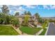 A view of a two-story home with stone accents, professional landscaping, and mature trees at 20166 E Shady Ridge Rd, Parker, CO 80134