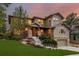 Beautiful two-story home with stone accents, landscaped yard, and a two-car garage at sunset at 20166 E Shady Ridge Rd, Parker, CO 80134