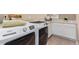 Modern laundry room with white cabinets, tile countertop, and front-loading appliances at 20166 E Shady Ridge Rd, Parker, CO 80134