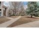 Well-maintained community grounds with sidewalks and mature trees between residential buildings at 1120 Opal St # 203, Broomfield, CO 80020