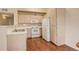 Efficient kitchen featuring white appliances, light wood cabinets and warm hardwood floors at 1120 Opal St # 203, Broomfield, CO 80020