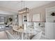 Well-lit dining room features a modern light fixture, seating for four, and built-in shelving at 5716 S Lisbon Way, Centennial, CO 80015