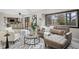 Inviting living room featuring a large window, stylish furniture, and access to the kitchen at 5716 S Lisbon Way, Centennial, CO 80015