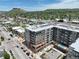 Aerial view showcases the modern apartments, nearby cityscape, and mountain views under a blue sky at 20 Wilcox St # 517, Castle Rock, CO 80104