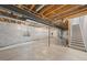 Unfinished basement with concrete floor, exposed ceiling, and staircase at 7310 Watercress Dr, Littleton, CO 80125