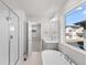 Bright bathroom with a soaking tub, glass-enclosed shower, and modern fixtures at 7310 Watercress Dr, Littleton, CO 80125
