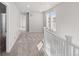 Upstairs hallway bathed in natural light with carpet flooring, and white railing at 7310 Watercress Dr, Littleton, CO 80125