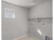 Compact laundry room with a small window and shelving for storage solutions at 7310 Watercress Dr, Littleton, CO 80125