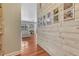 Hallway with a wall of Gathering photos and a view into a sunny living room with neutral tones at 5677 S Park Pl # B110, Greenwood Village, CO 80111