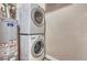 Laundry area featuring a stacked washer and dryer unit along with a hot water heater at 5677 S Park Pl # B110, Greenwood Village, CO 80111