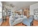 Bright living room features a comfortable white sofa, ottoman, hardwood floors, and modern ceiling fan at 5677 S Park Pl # B110, Greenwood Village, CO 80111