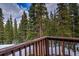 View from the wood balcony overlooking the forest with snow cover at 492 Kimmes Ln, Breckenridge, CO 80424