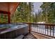 Relaxing hot tub on a wooden deck surrounded by beautiful evergreen trees and snow at 492 Kimmes Ln, Breckenridge, CO 80424