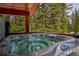 Outdoor hot tub on deck with mature forest view at 492 Kimmes Ln, Breckenridge, CO 80424