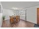 A dining room with hardwood floors, a dining table, and a large window at 6252 W 70Th Pl, Arvada, CO 80003