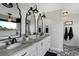 Modern bathroom with a double vanity, stylish mirrors, black hardware, and decorative tile flooring at 19185 Breton Pl, Monument, CO 80132