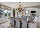 Bright dining room with large windows, an elegant chandelier, and a view into the living area at 19185 Breton Pl, Monument, CO 80132