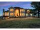 Breathtaking two-story home features a red tile roof, large windows, and lush green lawn at 19185 Breton Pl, Monument, CO 80132