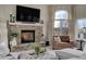 Warm living room featuring a stone fireplace, comfortable seating, and a large window for ample light at 19185 Breton Pl, Monument, CO 80132