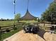 Outdoor patio with a modern shade sail, stylish dining set, and lush green lawn and golf course views at 653 Glenarbor Cir, Longmont, CO 80504