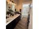 Beautiful bathroom features double sinks, stylish black fixtures, marble shower and updated vanity at 653 Glenarbor Cir, Longmont, CO 80504