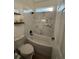 Bathroom with a shower over the tub featuring white and marble-look tile, and black fixtures at 653 Glenarbor Cir, Longmont, CO 80504
